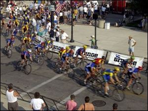 CTY cycle02p 080202 A  August 2, 2002-- Amatuer bicycle racers speed through the corner at Second and Louisiana in Perrysburg during the Perrysburg Grand Prix. Friday night's race was the first stop in the Tour of Ohio series. Blade photo by Andy Morrison