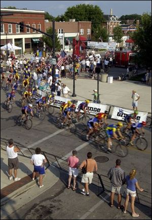 CTY cycle02p 080202 A  August 2, 2002-- Amatuer bicycle racers speed through the corner at Second and Louisiana in Perrysburg during the Perrysburg Grand Prix. Friday night's race was the first stop in the Tour of Ohio series. Blade photo by Andy Morrison