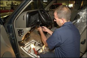 Mark Jasinski performs an ignition-switch recall repair on a Chrysler vehicle at Monroe Dodge Chrysler Jeep.
