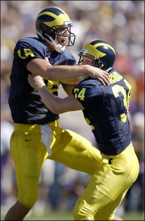 Michigan quarterback John Navarre celebrates with junior kicker Philip Brabbs after Brabbs drilled the game-winner from 44 yards out with no time left on the clock to beat Washington.