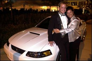 NEW TOY: Jeff and Tammy Fretti smile happily after they won the bidding for the 2003 Ford Mustang convertible.
 
