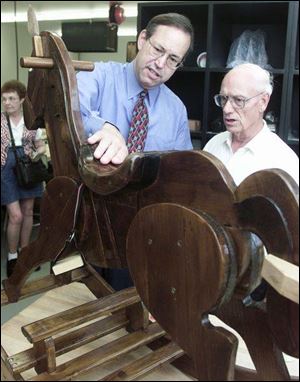 Bill Teaderman shows off a wooden horse he made in the Sylvania Senior Center's wood shop to Bob Taft during the governor's visit to the center yesterday.