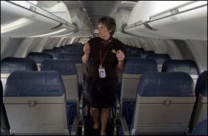 Cheri Newbold, a flight attendant, makes a preflight inspection of the cabin.
 