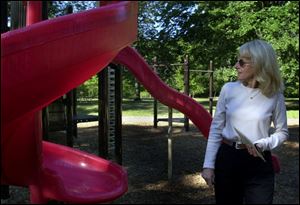 Barbara Lane, Toledo's superintendent of parks, looks over a slide at Ottawa Park.
