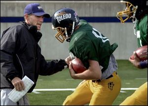 Rockets offensive coordinator Rob Spence tries to dislodge the ball from Brian Jones during a practice session.