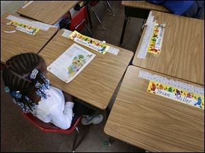 TaQuan Samuels sits amid empty desks as she works in her Pierre Toussaint Academy classroom.