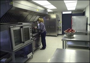 Rebecca Singer readies the 2,400-square-foot kitchen for tomorrow's grand opening.