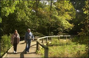 Jeanne and Bill Rouppas use the boardwalk at Wildwood Preserve Metropark. The park system has added 920 acres in the last decade, including an expansion of Wildwood, and more growth is eyed.