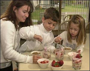 Betty Bassett and children, J.T., 7, and Victoria, 4, fix Yogurt Granola Parfaits.