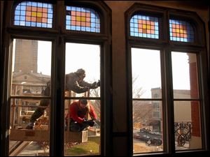 reg rover18p November 18, 2002. Eric Fourtner and Beth Brown of Rustain seal cracks in the windows of the Kagy building in downtown Tiffin, O. Blade photo by Jeremy Wadsworth