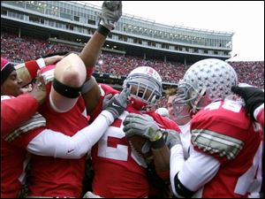 Ohio State free safety Will Allen (26) is mobbed by teammates after intercepting the last offensive play by Michigan.