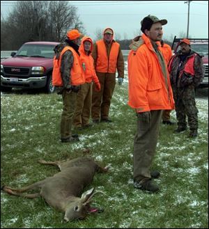 Don Keil of Toledo waits along State Rt. 15 just north of the Ohio Turnpike in Williams County with the four-point buck he bagged from about 40 yards.