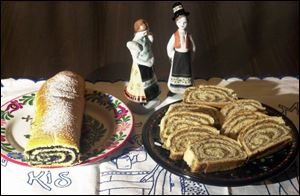An unsliced poppyseed roll, left, and slices of a nut roll, made by Mary Lou Tomsic are served on Hungarian plates that the family treasures.
