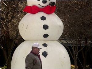 CTY  ROVE   LEVIS SQUARE.  CITY WORKER BRUCE NACHTRAB  CARRIES TRASH BY THE SNOWMAN IN THE SQUARE.  THE SNOWMAN SEEMS TO BE SMILING AT HIM.  DIANE HIRES 12-9-02