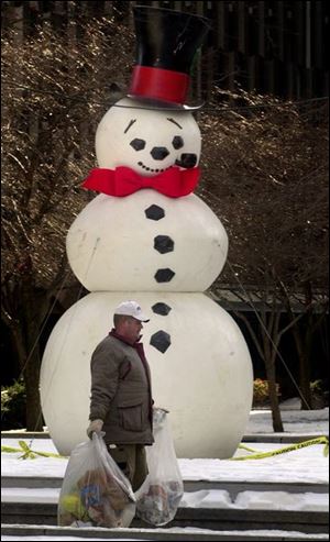 CTY  ROVE   LEVIS SQUARE.  CITY WORKER BRUCE NACHTRAB  CARRIES TRASH BY THE SNOWMAN IN THE SQUARE.  THE SNOWMAN SEEMS TO BE SMILING AT HIM.  DIANE HIRES 12-9-02