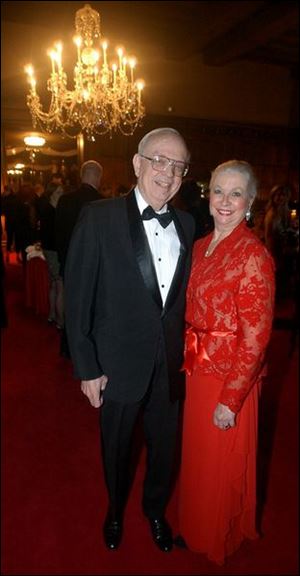 Richard S. Baker with his wife, Barbara, who brightened the party in her attractive red gown.