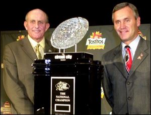 Miami coach Larry Coker, left, and Ohio State boss Jim Tressel eye the object of tonight's Fiesta Bowl - the national championship trophy. Coker's Hurricanes have a quick-strike offense. Tressel's Buckeyes have an excellent defense.