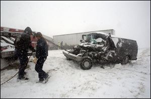 A towing crew removes a van, left, after an accident on I-75 in Perrysburg Township