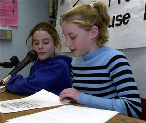 Molly Hilfinger, left, and Ashlee French, both 9, practice the piece they will read as anchors for the TV show.