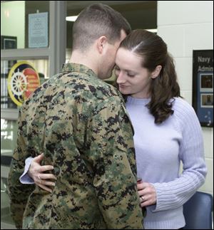 Lance Cpl. Brad Compton and his wife, Sarah, embrace before she leaves his side to attend a meeting on insurance with other spouses. He returned home three weeks ago after serving six months in South America.