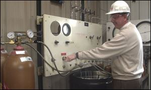 Cliff Caldwell fills hydrogen cylinders at AGA Gas, Inc., in Maumee, which supplies the gas for fuel cell research.