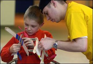 Connor Kapperman, 9, of Weston and Jeff Holda, a mechanical engineering student at the University of Toledo, work on a model plane during the Technorama Fair at UT.