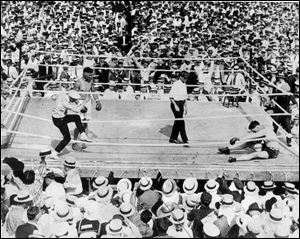 Jess Willard, right, crumples on the mat after a battering by boxer Jack Dempsey during a July 4, 1919, title fight at Bay View Park in Toledo.