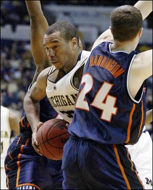 LaVell Blanchard, who led Michigan with 25 points, squeezes through Illinois' Sean Harrington (24) and Roger Powell.