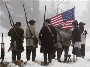 Raising Old Glory in Chillicothe are members of the Ohio County Militia, Civil War historical re-enactors.