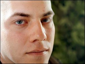 U.S. Army Capt. Greg Holden has shrapnel in his stomach, and both legs are broken.