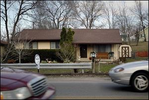 Traffic zips past a house offered for sale on South Wheeling Street in the suburb of Oregon, east of Toledo.