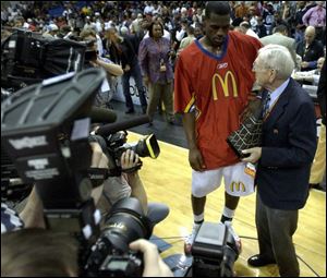 LeBron James is the center of attention as he receives the MVP trophy from lengendary coach John Wooden.