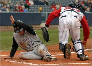 Louisville's Ryan Freel scores a run, a scene Toledo catcher A.J. Hinch had to watch 15 times. The Bats pounded out 20 hits while the Hens fanned 16 times.