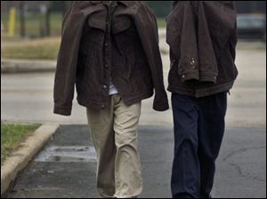 Levell Lane, 10, left, and his brother, Louis, 6, bundle against the cold on their walk home from the Paul Laurance Dunbar Academy. A warming trend beginning today will boost temperatures at least through Sunday.
