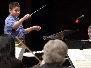 The Toledo Symphony Orchestra performs at the Stranahan Theater under the baton of Joey Ybarra. The orchestra let area youths try their hand at conducting yesterday.
