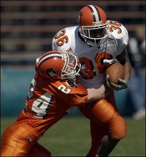 Joe Dyer, playing for the Orange team, tackles Derrick Lett, who caught the winning TD pass for the White team.