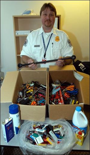 Mickey Thompson, a Toledo Express Airport screener, displays the banned items seized from airplane travelers.