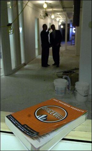 An Officeville catalog sits in an area the company is remodeling to add 3,500 square feet of space. Scott Wayne, left, and Louis Meeks are in the background.