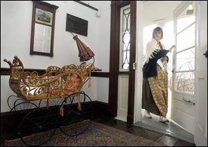 A Gendron baby carriage manufactured about 1870 in Toledo that's part of an Ohio Bicentennial exhibit is parked inside the entrance to the Wolcott House Museum as employee Peggy Earhart arrives for work.