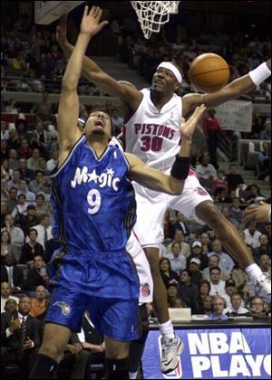 Detroit's Cliff Robinson battles Orlando's Drew Gooden last night in Game 2 of their first-round playoff series. The Pistons, who led by as many as 22 points in the second quarter, never trailed in the game.
