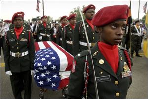 Valencia Robertson, foreground, leads a Reserve Officer Training Corps honor guard from Northwestern High in Detroit during the parade in Monroe. The empty casket symbolizes servicemen who gave their lives in teh line of duty.