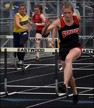 Senior Chelsea Shelnick of Stritch, who repeated as a league champ, leads a hurdle event.