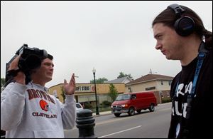 Bowling Green State University students Kevin Stone, left, and Jeremy Rober decide what to do next after they were asked to leave the Salvation Army Thrift Store, in the background, where they wanted to film for their reality TV program. 