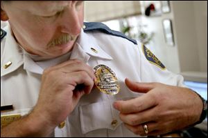 Lt. Ken Fortney pins on one of the new badges.