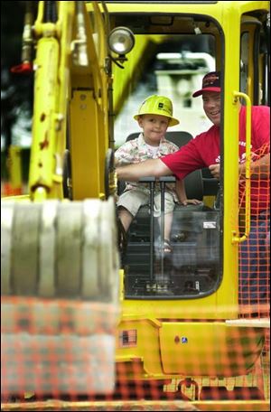 Grant Denhof, 3, whose mother says he's `obsessed' with large machinery, gets a chance to operate one at COSI with the help of Tony Farkasdi of the Ohio Operating Engineers.