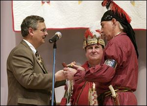 United Methodist Bishop Bruce Ough, left, receives a peace pipe from Larry 'Ayapia' Eveland, a Shawnee Indian from Cincinnati, as the two exchange gifts of reconciliation. Looking on is Rev. Fred Shaw, a Methodist pastor and Shawnee storyteller.