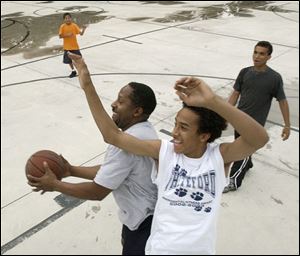 Everett DuPree is blocked by his son Josh, 13, on his way to the basket during a friendly game of basketball while Jacob, 10, rear left, and Tony, 17, take in the action. Mr. DuPree, of Ottawa Lake, Mich., said he didn't hesitate to become a single father in 1996. Tony now lives with his ex-wife, who also shares decision-making duties for the other children.