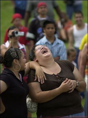 Roquel Rodriguez, left, and Debbie Sanchez share a laugh while listening to music of the Midwest Godfathers.