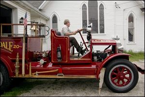 Firefighter Bob Hintz pulls the Clyde Fire Department's old-fashioned Clydesdale fire truck, produced in Clyde, out of the city's museum.