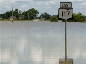 All that can be seen of State Rt. 117 amid the flooding in Rockford, Ohio, is the route marker.